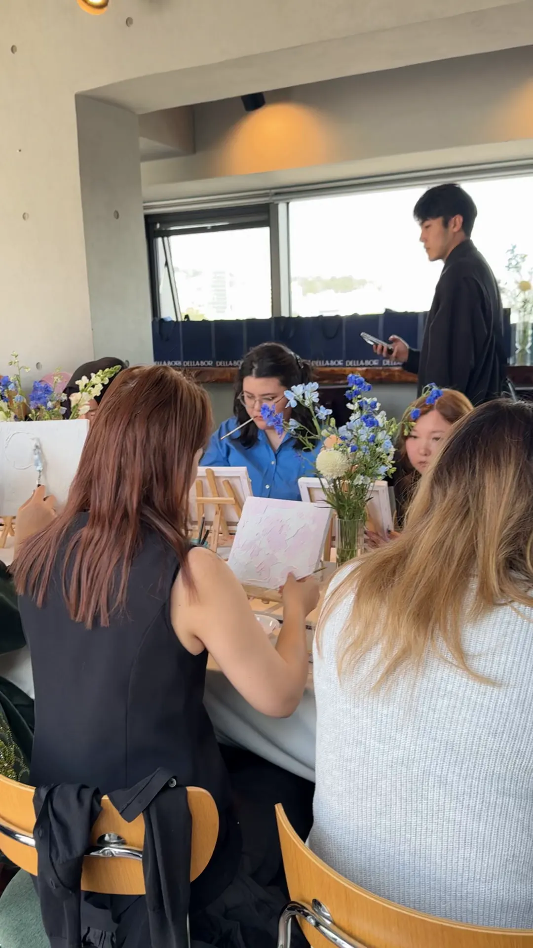 Members painting and talking at shared tables