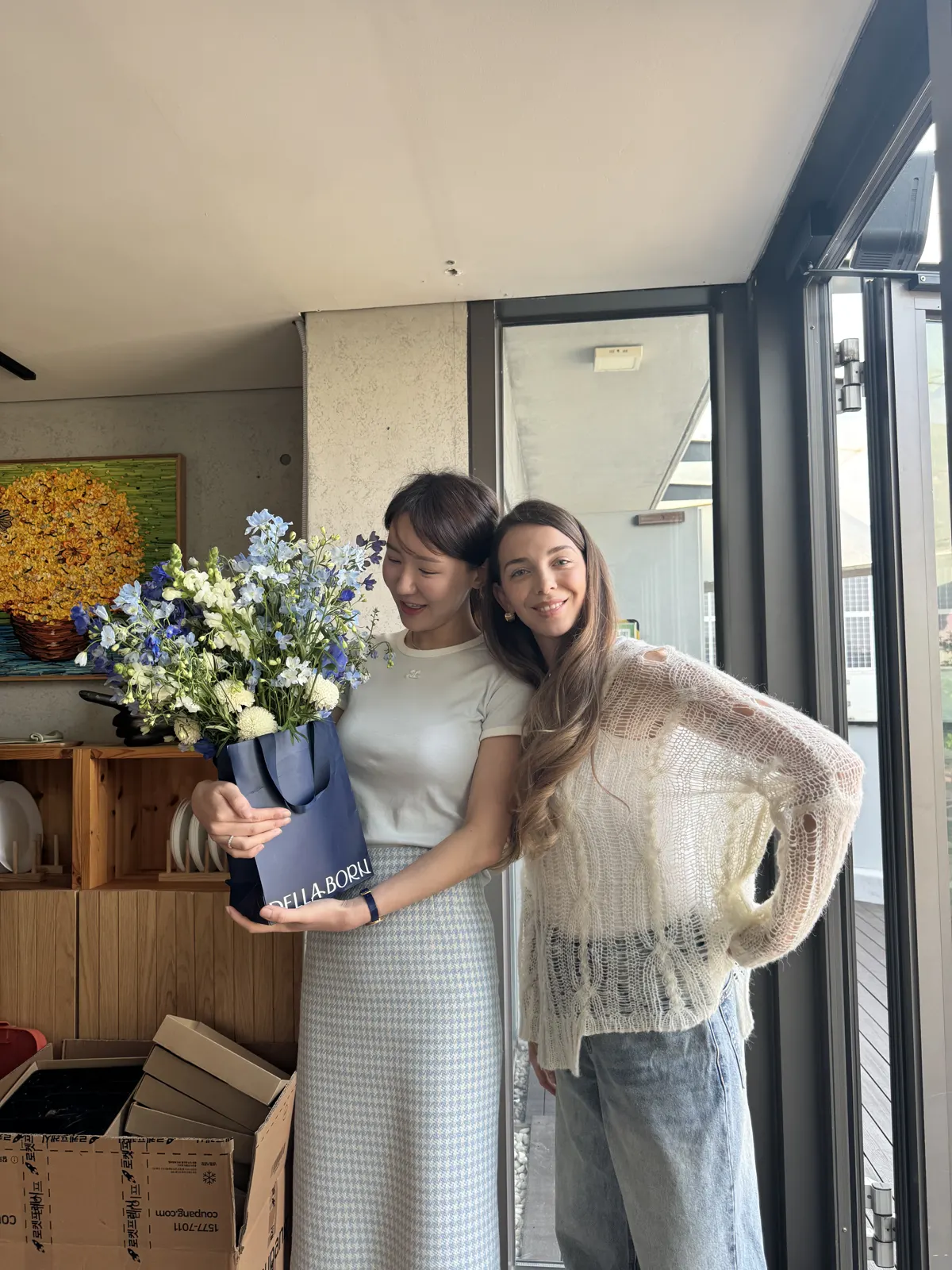 Two women posing with flowers at the gathering